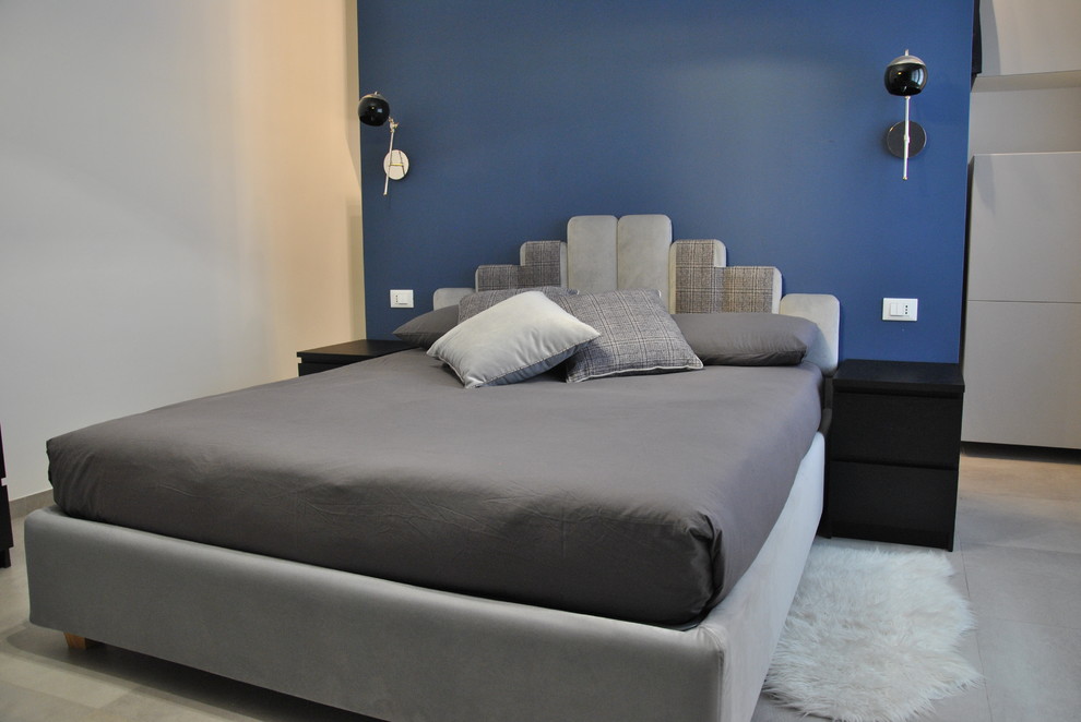ローマにある広いモダンスタイルのおしゃれな主寝室 (青い壁、磁器タイルの床、グレーの床) のレイアウト