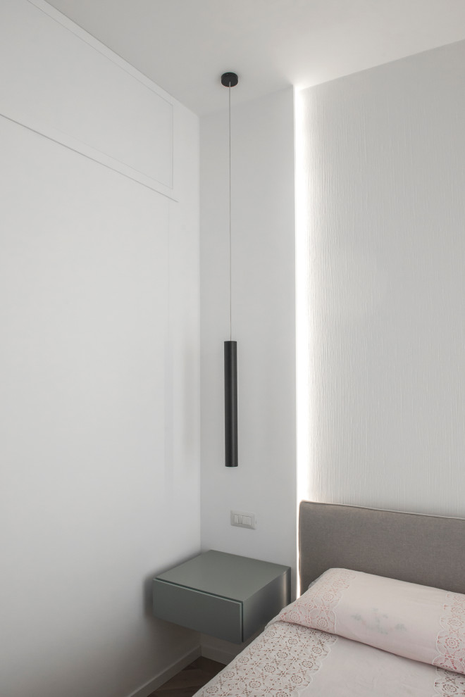 Immagine di una camera matrimoniale design di medie dimensioni con pareti bianche, pavimento in legno massello medio e pavimento marrone