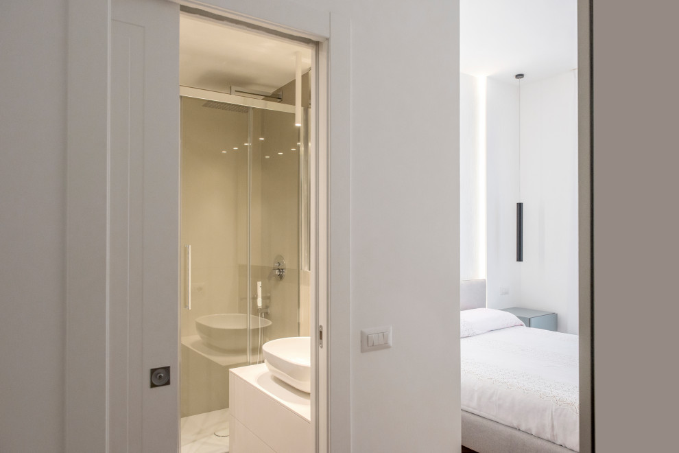 Immagine di una camera matrimoniale design di medie dimensioni con pareti bianche, pavimento in legno massello medio e pavimento marrone