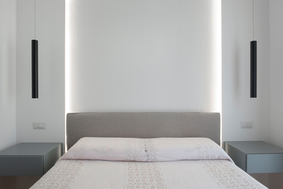Imagen de dormitorio principal actual de tamaño medio con paredes blancas, suelo de madera en tonos medios y suelo marrón