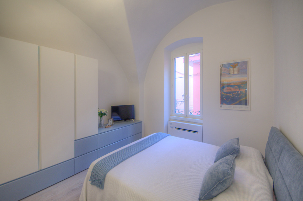 Ispirazione per una camera matrimoniale mediterranea con pareti bianche e pavimento in laminato