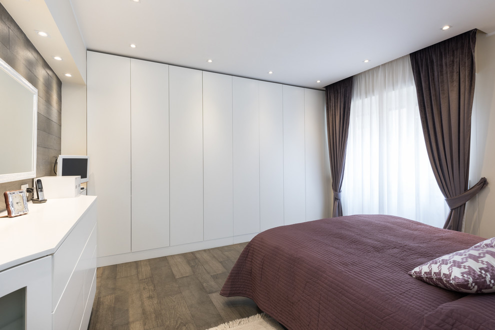 На фото: хозяйская спальня в современном стиле с белыми стенами и полом из керамогранита без камина с