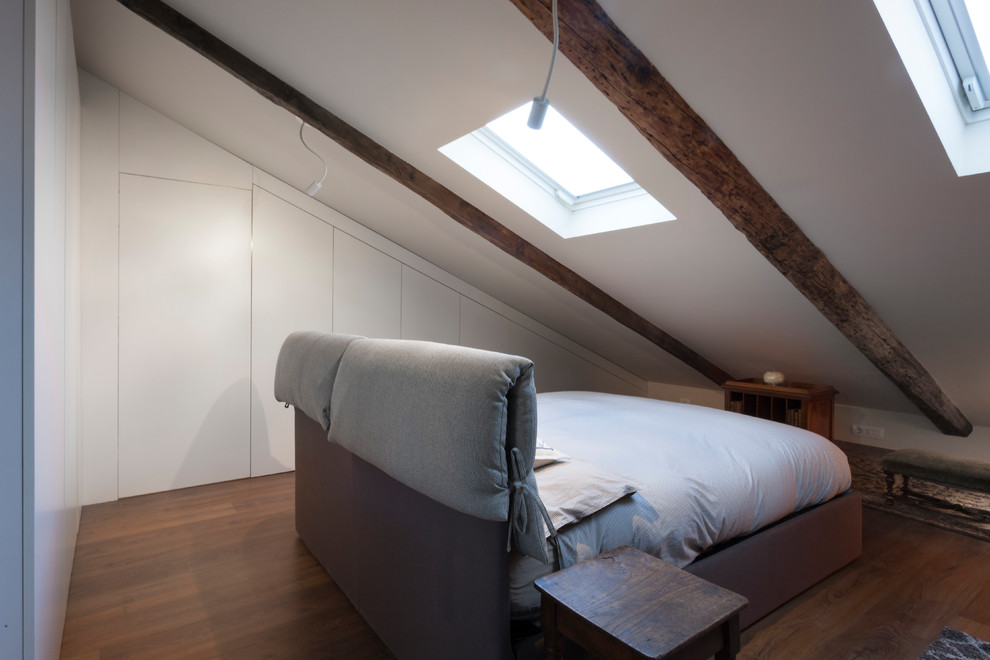 Ejemplo de dormitorio tradicional con techo inclinado