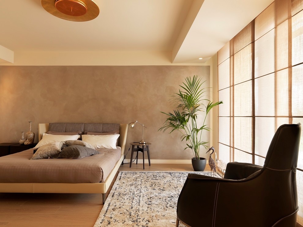 На фото: хозяйская спальня в современном стиле с коричневыми стенами, светлым паркетным полом и бежевым полом с
