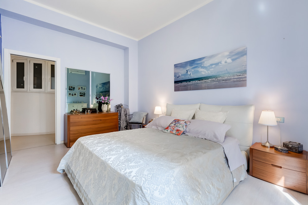 Idee per una grande camera matrimoniale minimalista con pareti blu, pavimento in laminato e pavimento beige