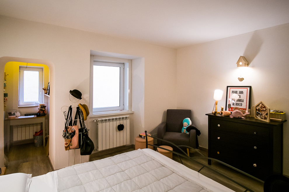 На фото: хозяйская спальня среднего размера в стиле шебби-шик с белыми стенами, полом из ламината и коричневым полом с