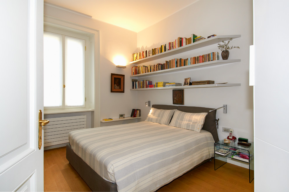 ミラノにあるコンテンポラリースタイルのおしゃれな寝室 (白い壁、無垢フローリング、茶色い床) のレイアウト