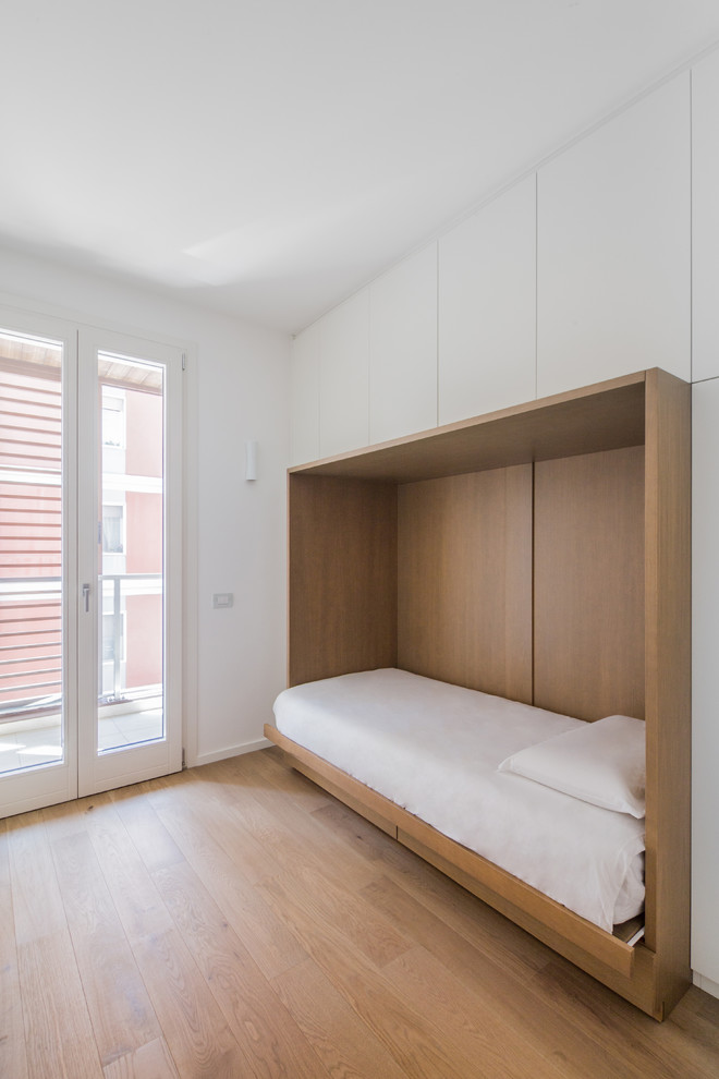 Modernes Schlafzimmer mit weißer Wandfarbe und hellem Holzboden in Cagliari