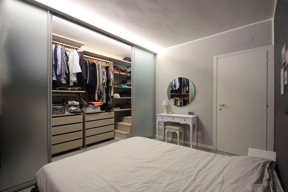 Photo of a large modern master bedroom in Milan with grey walls, ceramic flooring, a wood burning stove and grey floors.