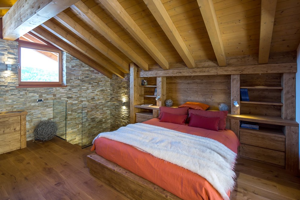 Cette image montre une chambre parentale chalet de taille moyenne avec un sol en bois brun.