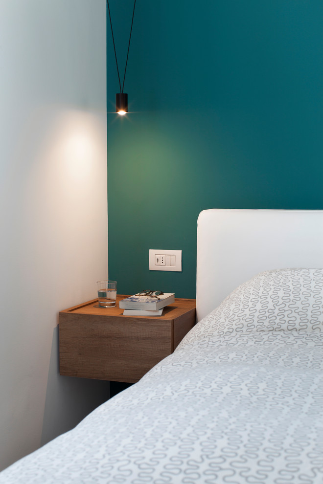 Modelo de dormitorio principal contemporáneo pequeño con paredes azules, suelo de cemento y suelo gris