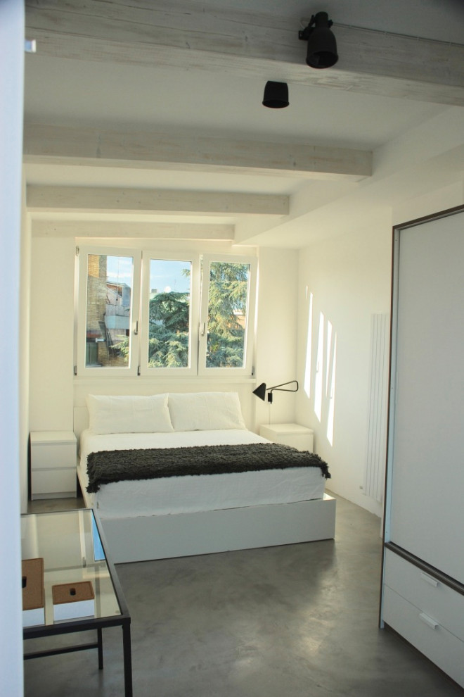 Foto de dormitorio principal nórdico de tamaño medio con paredes blancas, suelo de cemento y suelo gris