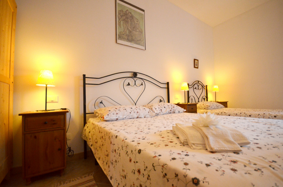 Imagen de habitación de invitados beige y blanca romántica grande con paredes blancas, suelo de baldosas de porcelana y suelo beige