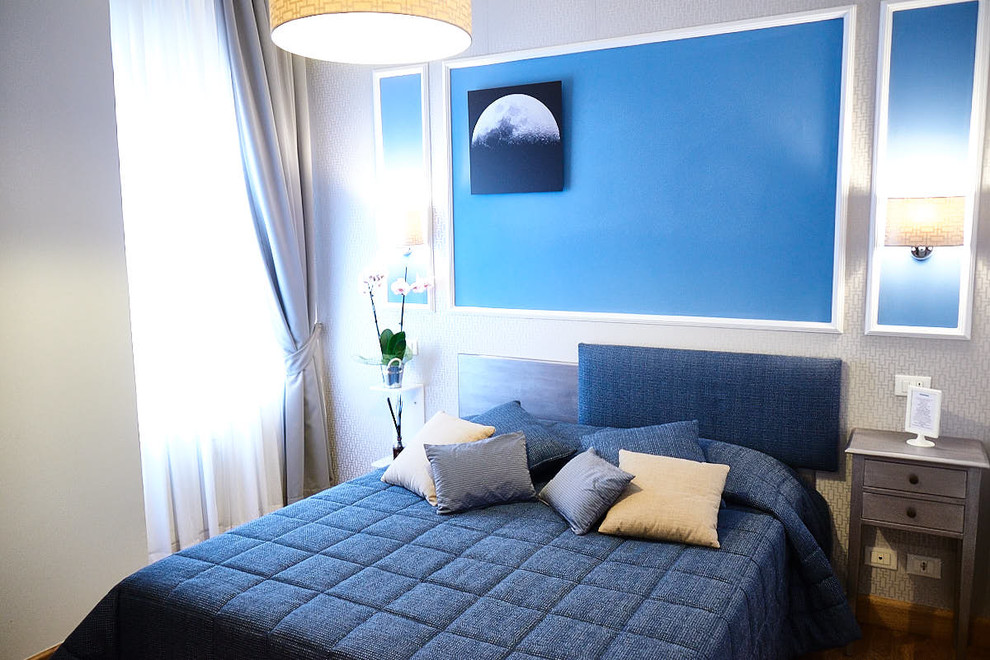 Ispirazione per una grande camera matrimoniale design con pareti blu e parquet chiaro