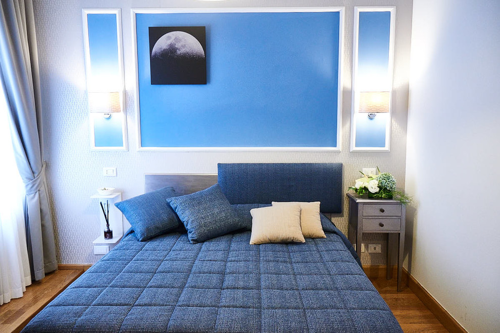 Idee per una grande camera matrimoniale contemporanea con pareti blu e parquet chiaro