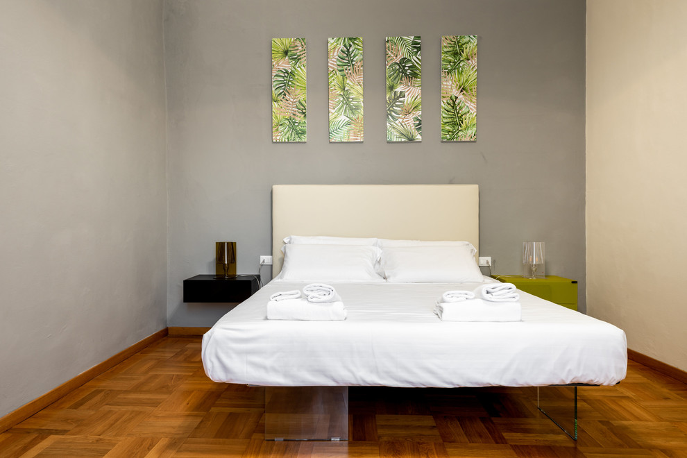 Foto di una camera matrimoniale minimalista di medie dimensioni con pavimento in legno massello medio e pavimento marrone