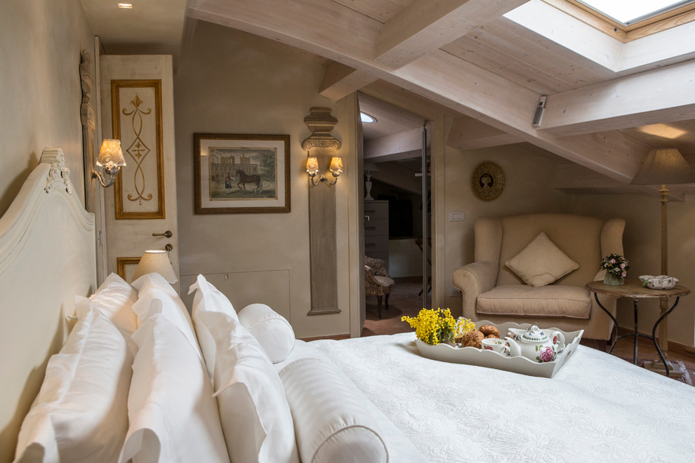 Foto di una camera da letto country con pareti beige e parquet chiaro