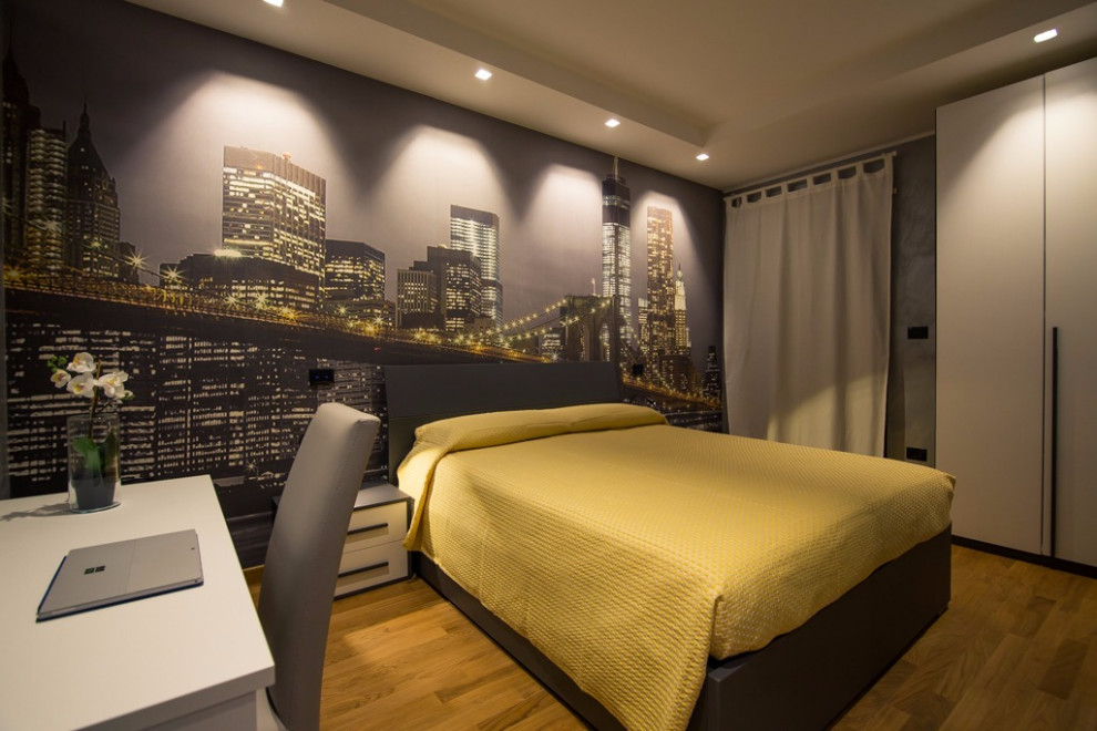 Ispirazione per una piccola camera degli ospiti minimalista con pareti multicolore, parquet chiaro, pavimento marrone e carta da parati