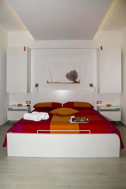 Esempio di una camera da letto costiera di medie dimensioni con pareti bianche, pavimento in gres porcellanato e pavimento beige