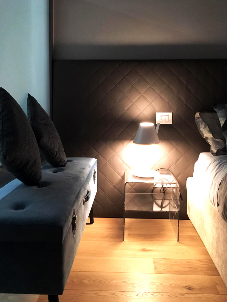 Kleines Modernes Hauptschlafzimmer mit weißer Wandfarbe und hellem Holzboden in Turin