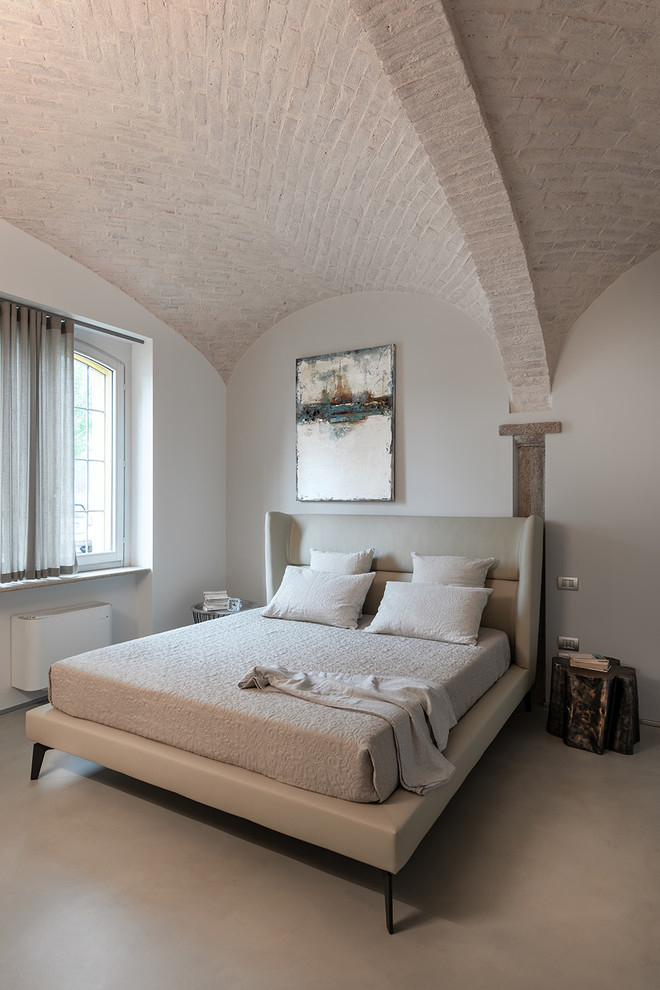 Medelhavsstil inredning av ett sovrum, med grå väggar och grått golv