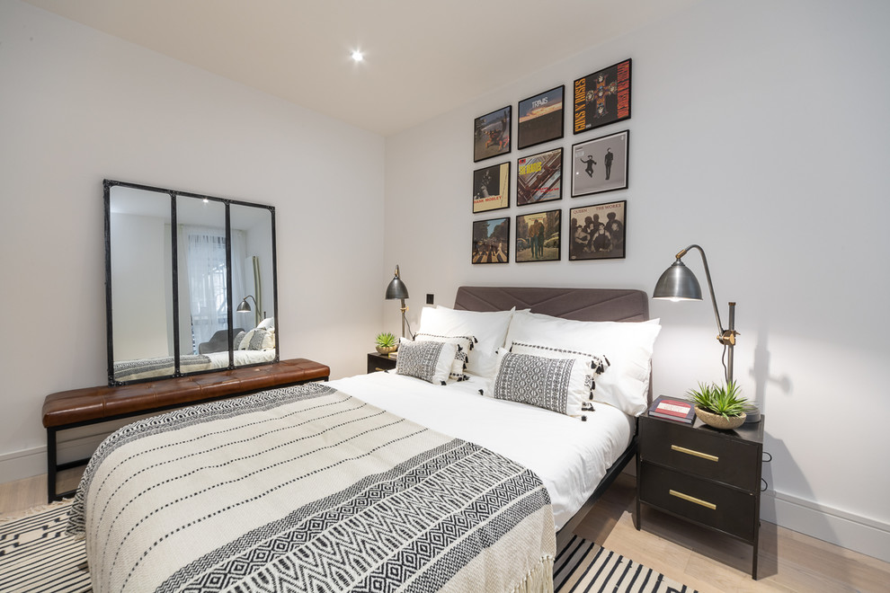 Skandinavisches Schlafzimmer ohne Kamin mit weißer Wandfarbe, hellem Holzboden und beigem Boden in London