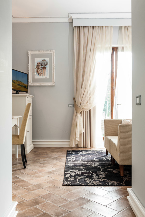 Aménagement d'une chambre parentale contemporaine avec un mur gris, un sol en carrelage de porcelaine et un sol marron.