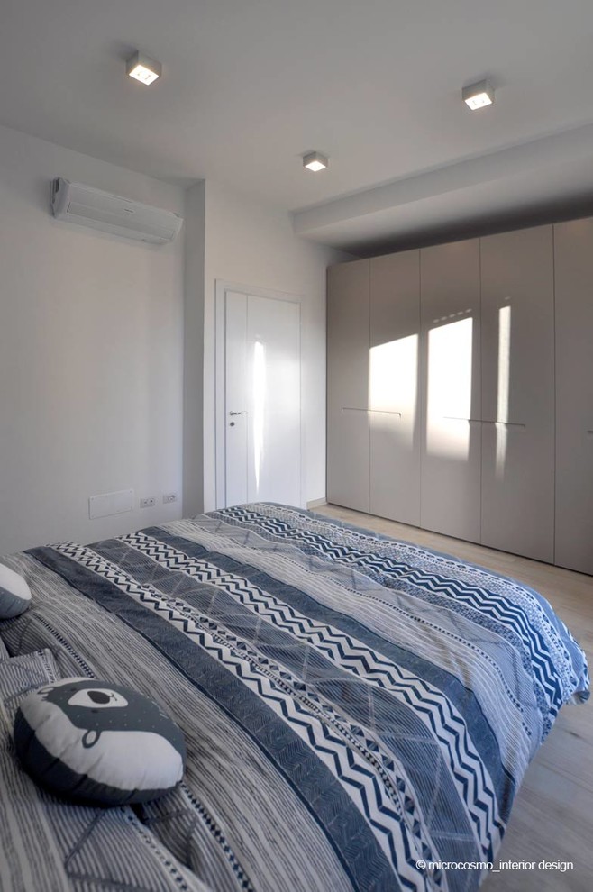 Ejemplo de dormitorio principal escandinavo pequeño con paredes blancas, suelo de baldosas de porcelana y suelo beige