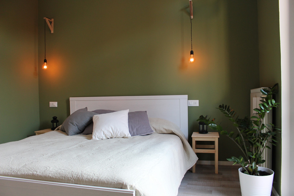 Diseño de dormitorio principal escandinavo de tamaño medio con paredes verdes y suelo laminado