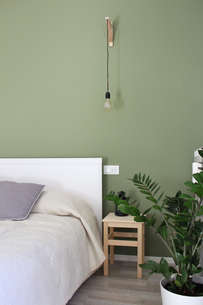 Стильный дизайн: хозяйская спальня среднего размера в скандинавском стиле с зелеными стенами и полом из ламината - последний тренд