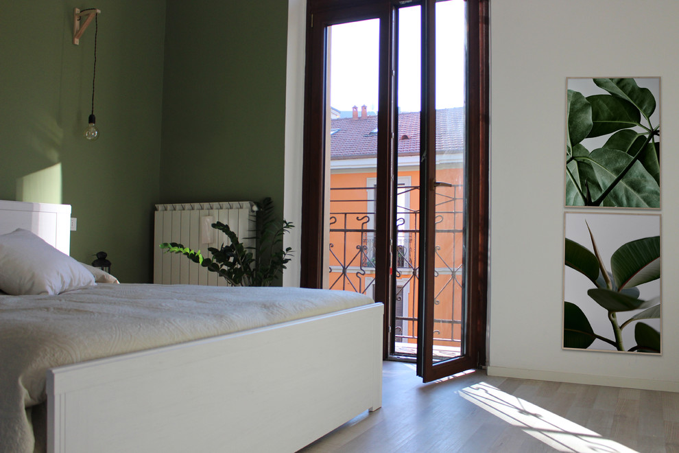 Medium sized scandinavian master bedroom in Milan with green walls and laminate floors.