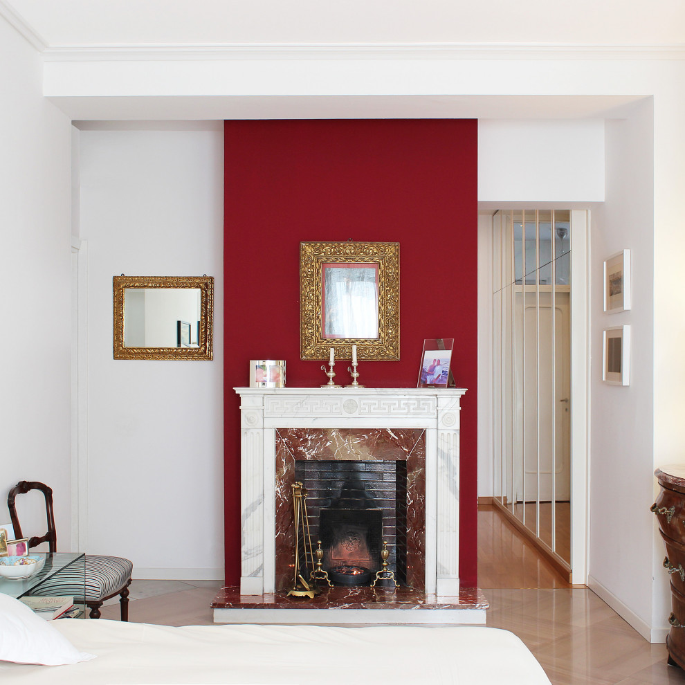 Источник вдохновения для домашнего уюта: большая хозяйская спальня в классическом стиле с красными стенами, стандартным камином, фасадом камина из камня и светлым паркетным полом