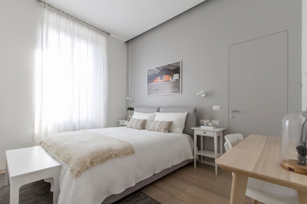 Foto de dormitorio principal moderno de tamaño medio con paredes blancas y suelo de madera en tonos medios