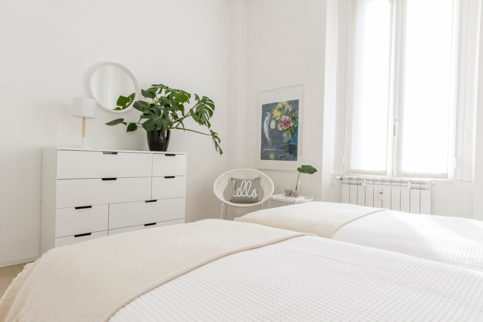 На фото: гостевая спальня среднего размера, (комната для гостей) в стиле модернизм с белыми стенами и паркетным полом среднего тона