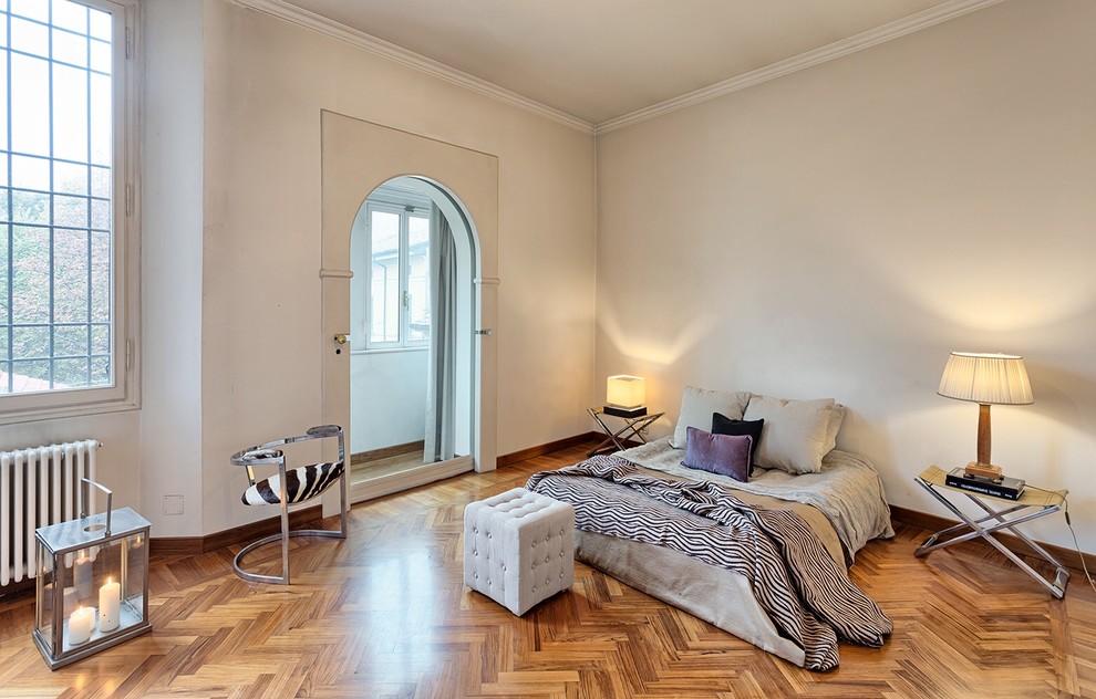 Foto de dormitorio principal actual grande con paredes blancas y suelo de madera en tonos medios