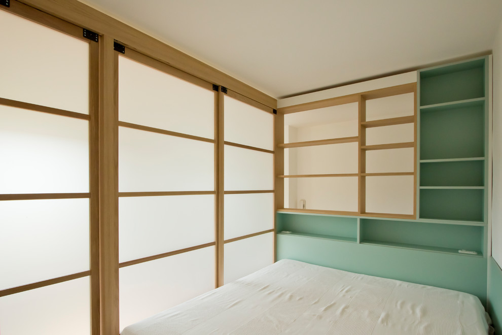 Aménagement d'une petite chambre mansardée ou avec mezzanine scandinave avec parquet clair et un sol marron.