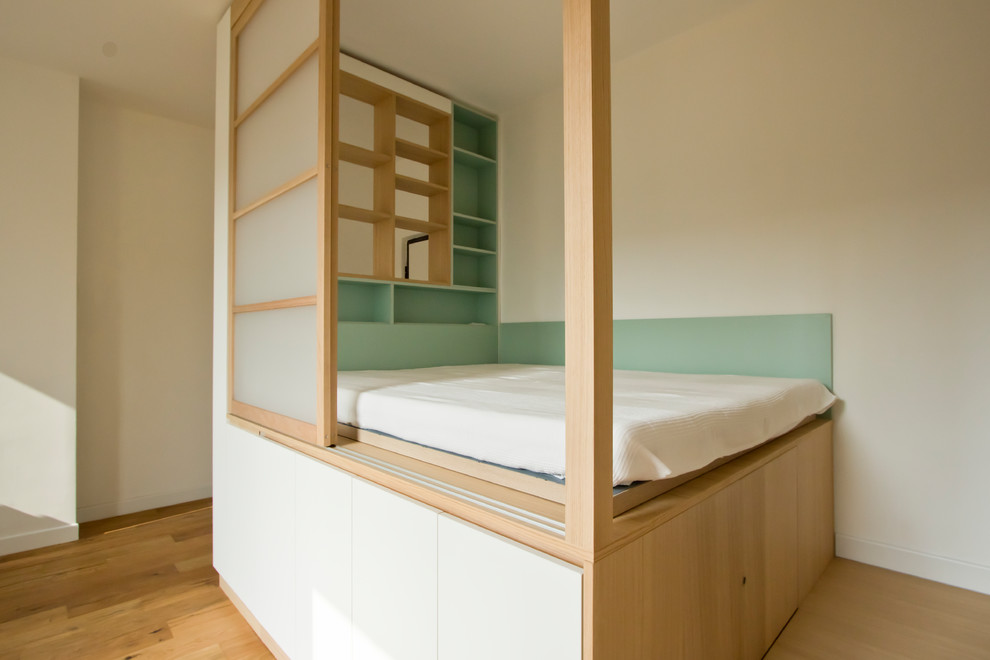 Bild på ett litet minimalistiskt sovloft, med ljust trägolv och brunt golv