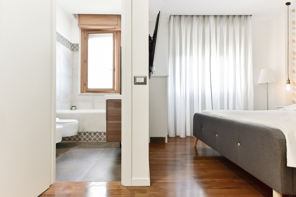 Small modern master bedroom in Rome with white walls and dark hardwood flooring.