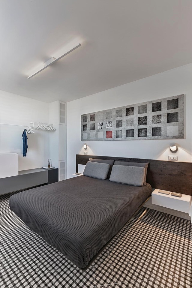 Modelo de dormitorio principal minimalista de tamaño medio con paredes blancas, suelo de ladrillo y suelo multicolor