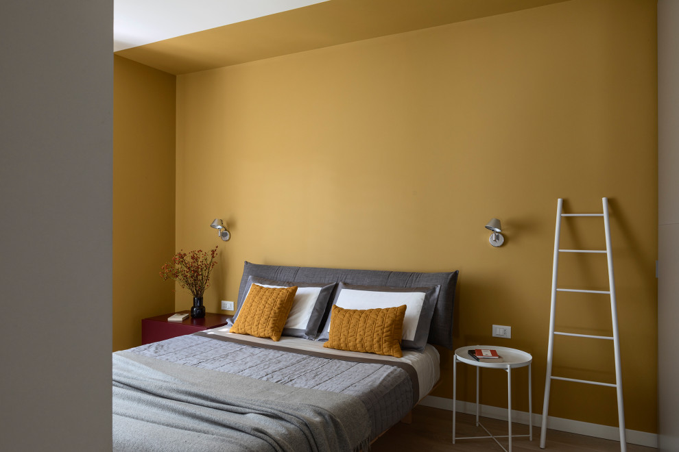 На фото: хозяйская спальня среднего размера в современном стиле с желтыми стенами и коричневым полом