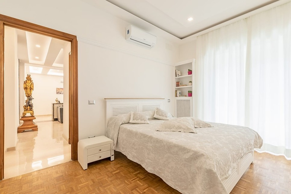 This is an example of a medium sized scandi master bedroom in Rome with white walls, medium hardwood flooring, beige floors and no fireplace.