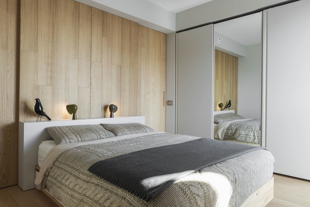 Ispirazione per una camera degli ospiti minimal con pareti grigie, parquet chiaro e pavimento beige