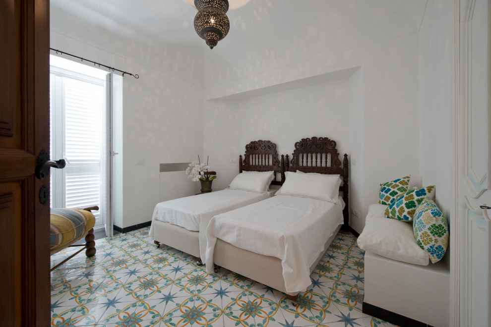 Ispirazione per una camera da letto mediterranea di medie dimensioni con pareti bianche, pavimento con piastrelle in ceramica e pavimento multicolore