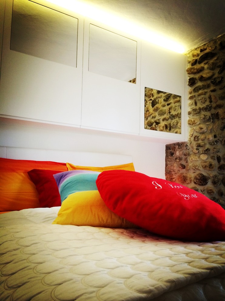 Ejemplo de dormitorio principal contemporáneo pequeño con paredes multicolor y suelo de baldosas de terracota