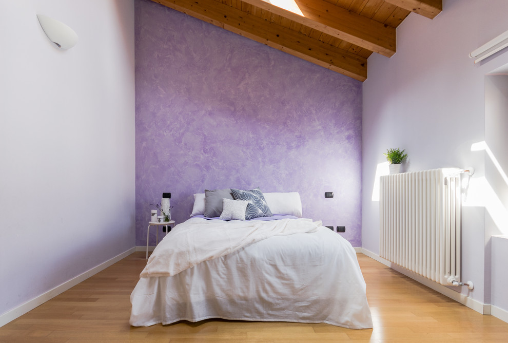 Cette photo montre une chambre parentale nature de taille moyenne avec un mur violet et un sol en bois brun.