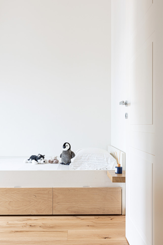 Modelo de habitación de invitados nórdica de tamaño medio con paredes blancas, suelo de madera clara y bandeja