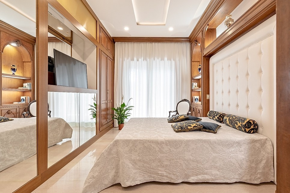 Diseño de dormitorio principal clásico grande con paredes blancas, suelo de mármol y suelo beige
