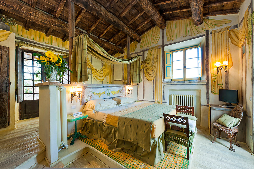 Diseño de dormitorio principal rústico con suelo de madera clara y paredes beige