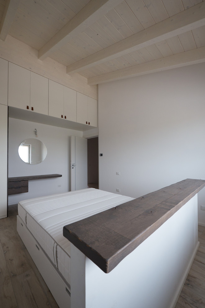 На фото: хозяйская спальня среднего размера в современном стиле с белыми стенами, полом из керамогранита и бежевым полом
