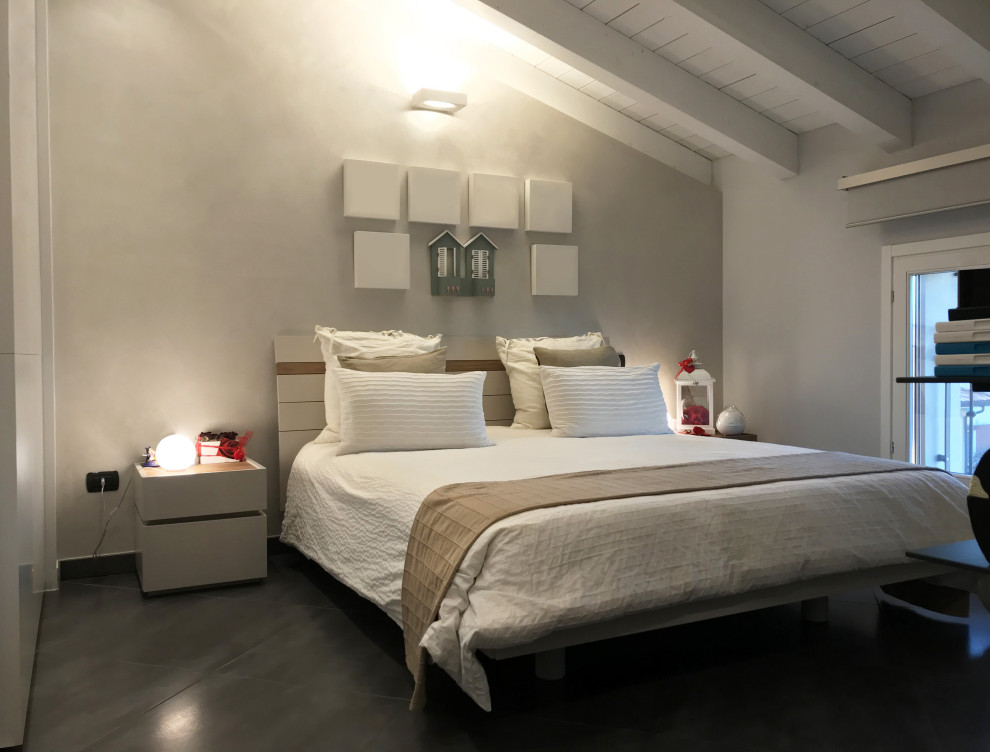 Immagine di una camera da letto stile loft moderna di medie dimensioni con pareti beige, pavimento in linoleum, nessun camino e pavimento grigio